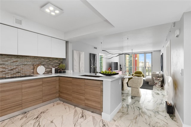 kitchen with sink, black electric stovetop, white cabinets, and backsplash