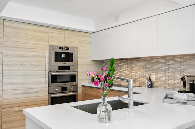 kitchen with double oven, sink, and decorative backsplash