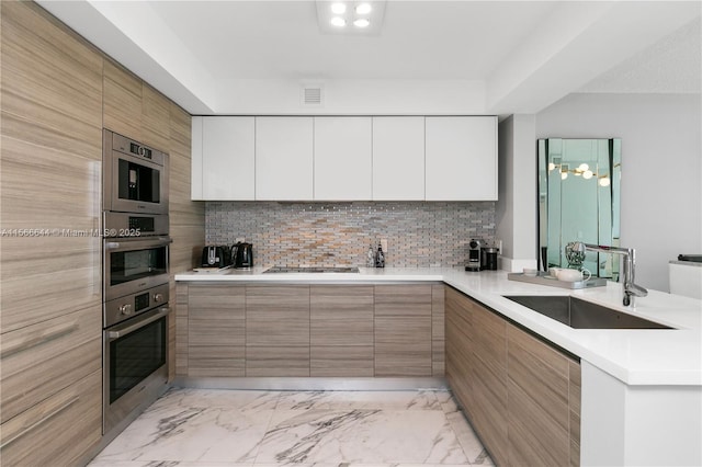 kitchen featuring white cabinetry, backsplash, sink, and black electric stovetop