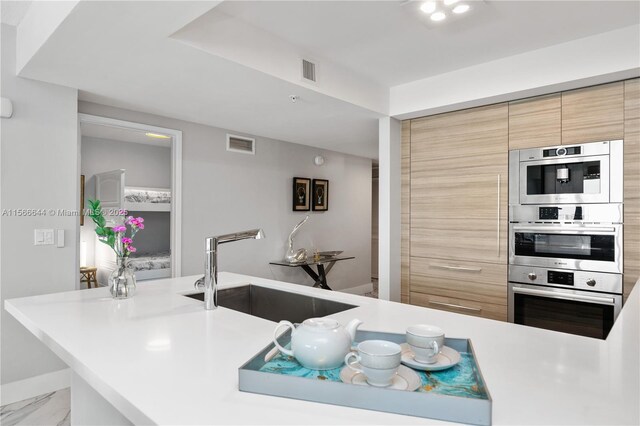 kitchen featuring sink, backsplash, kitchen peninsula, a textured ceiling, and white cabinets