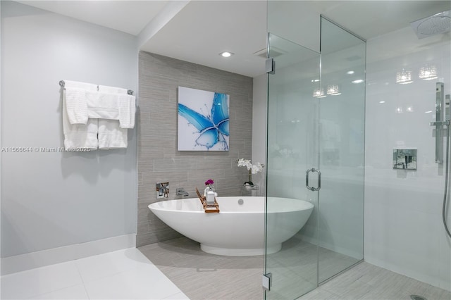 bathroom with tile walls, tile patterned flooring, and independent shower and bath