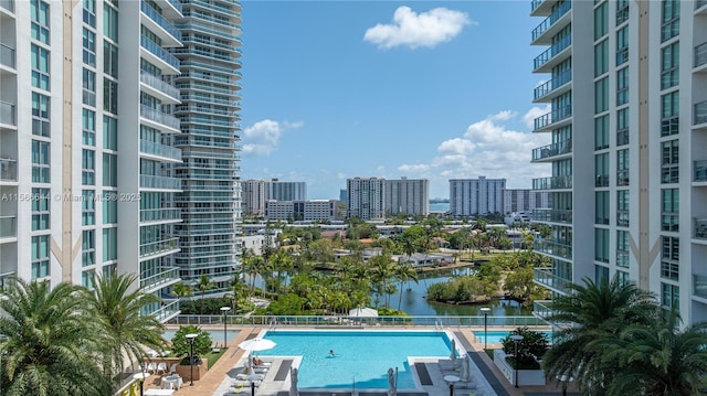 view of swimming pool featuring a patio and a water view