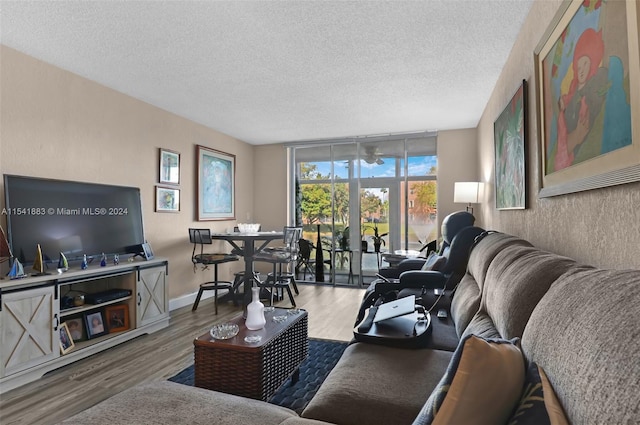 living room featuring a wall of windows, a textured ceiling, and hardwood / wood-style flooring