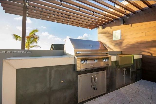 view of patio featuring exterior kitchen, a grill, and a pergola