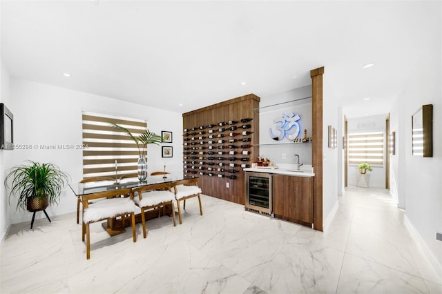 dining space with beverage cooler, sink, and light tile floors