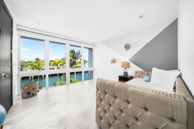 bedroom with light tile floors and a water view