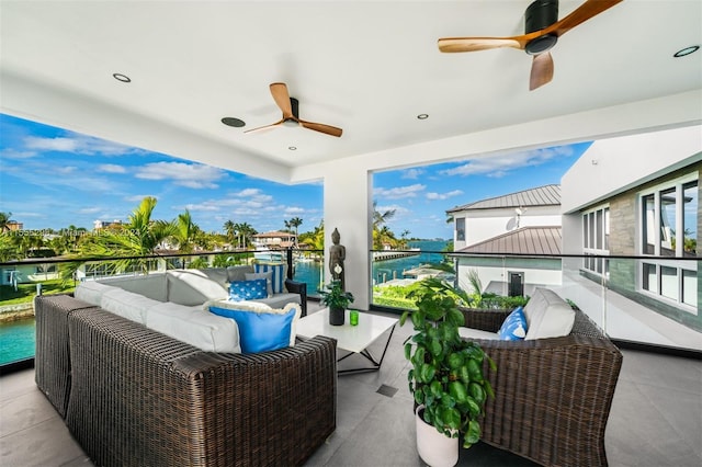 view of patio with a balcony, a water view, ceiling fan, and outdoor lounge area