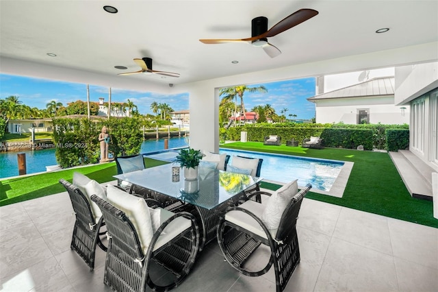 view of patio / terrace featuring a fenced in pool, ceiling fan, and a water view