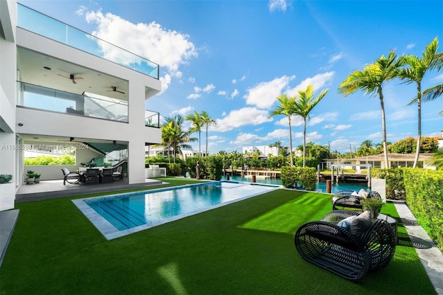 view of pool featuring a yard and ceiling fan