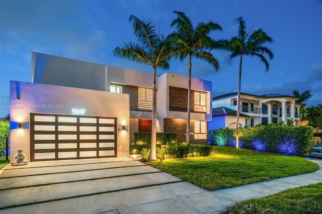 modern home with a yard, a garage, and a balcony