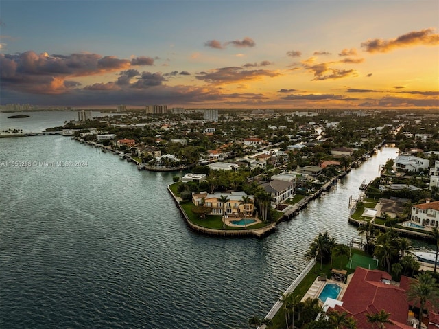 aerial view at dusk featuring a water view