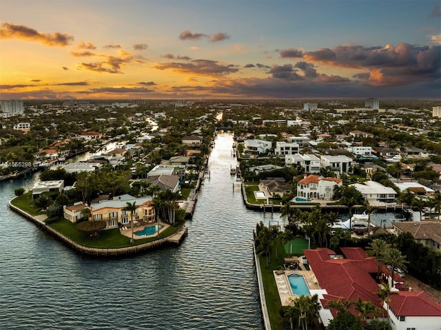 aerial view at dusk featuring a water view