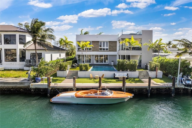 back of house featuring central AC unit, a balcony, a pool, and a water view