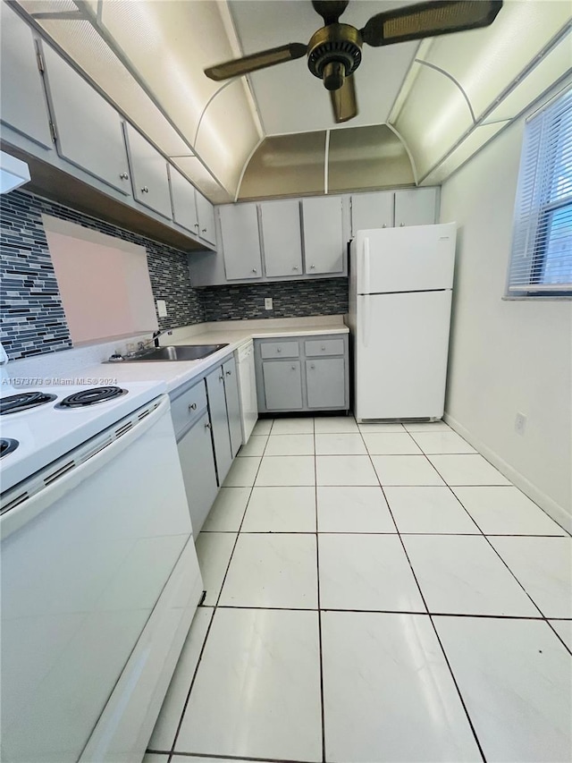 kitchen with white appliances, backsplash, light tile floors, sink, and ceiling fan