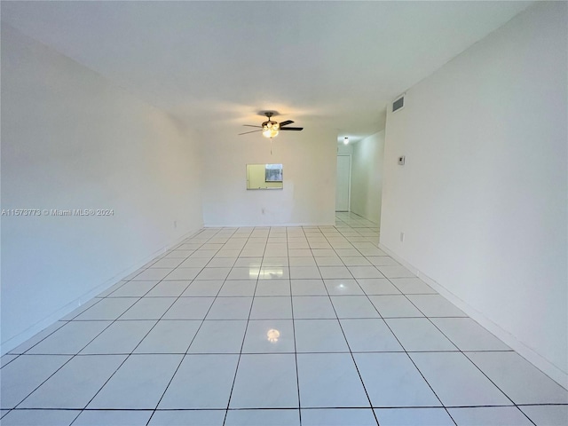 spare room with ceiling fan and light tile floors