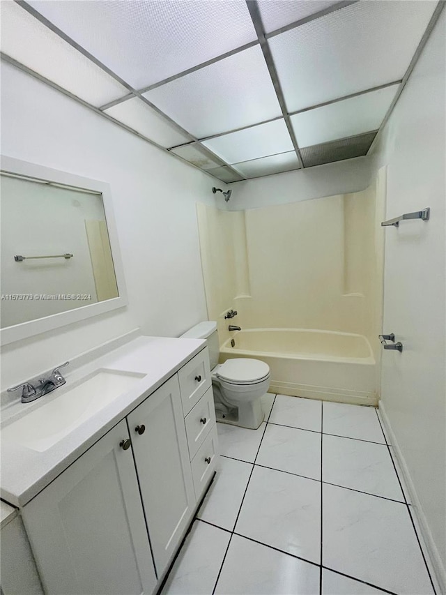 full bathroom featuring tile flooring, a paneled ceiling, tub / shower combination, toilet, and vanity