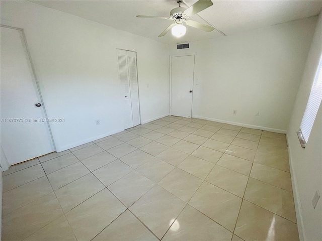 tiled spare room featuring ceiling fan