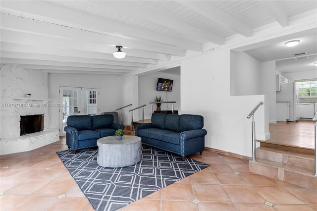 tiled living room with french doors, beamed ceiling, and a fireplace