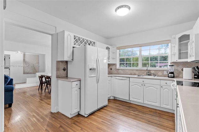 kitchen featuring white cabinetry, white appliances, backsplash, and light wood-type flooring