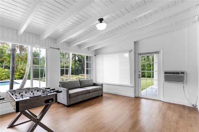 sunroom / solarium with beamed ceiling, plenty of natural light, and a wall mounted AC