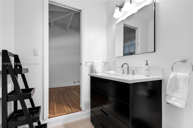 bathroom featuring hardwood / wood-style floors, vanity, and beam ceiling