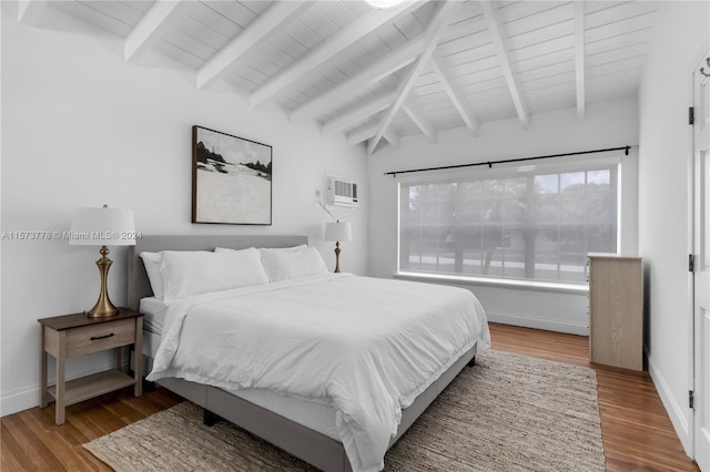 bedroom featuring lofted ceiling with beams, a wall mounted AC, and hardwood / wood-style floors