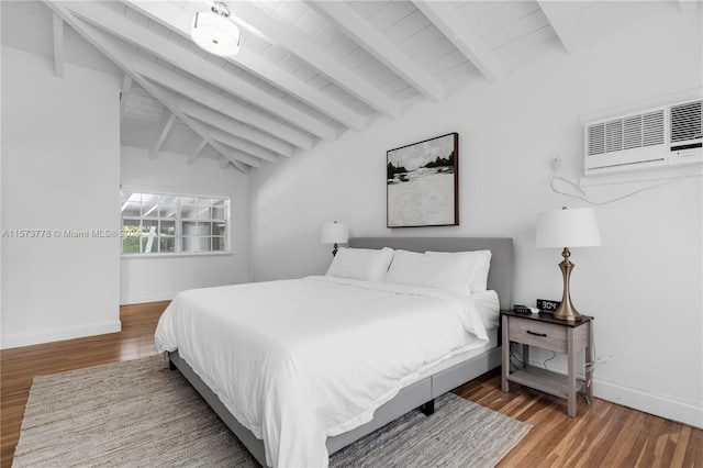 bedroom with hardwood / wood-style floors, lofted ceiling with beams, and a wall mounted air conditioner