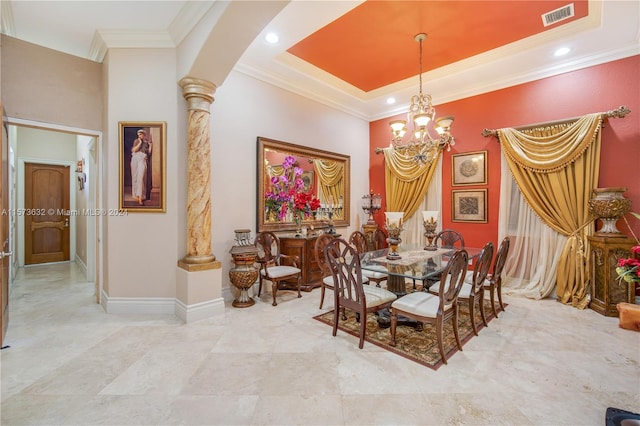 tiled dining room featuring a raised ceiling, ornamental molding, a chandelier, and decorative columns