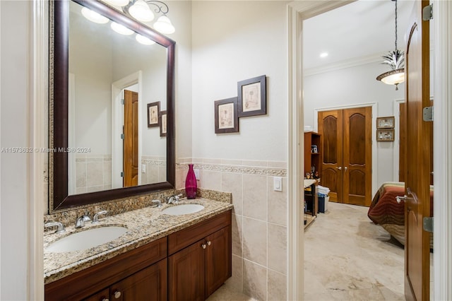 bathroom featuring crown molding, tile floors, tile walls, and double sink vanity