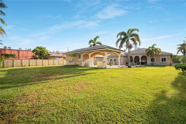 back of house featuring a lawn and a patio