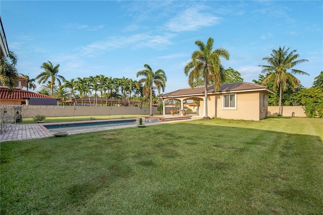 view of yard with a fenced in pool and a patio