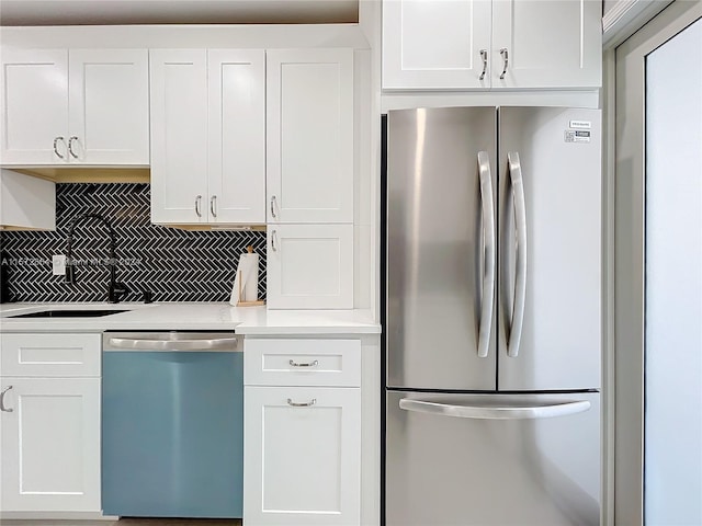 kitchen featuring white cabinetry, appliances with stainless steel finishes, sink, and decorative backsplash