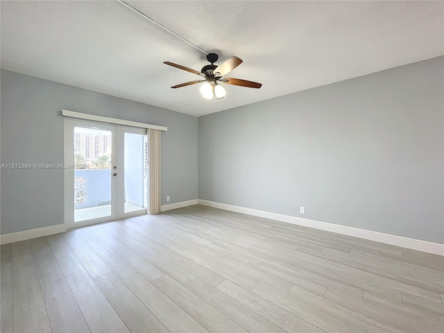 empty room featuring ceiling fan, a textured ceiling, light hardwood / wood-style floors, and french doors