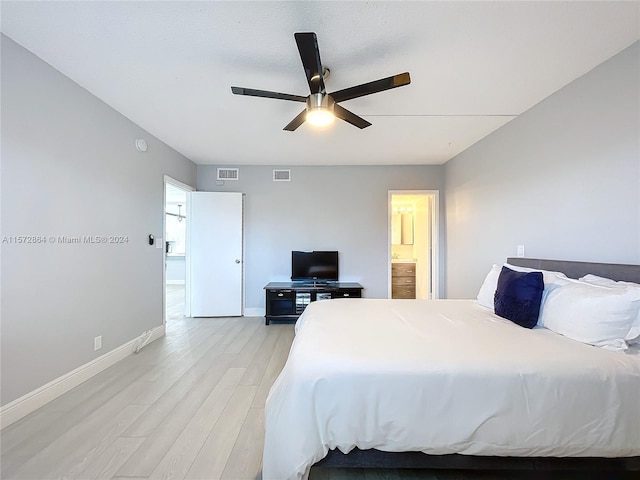 bedroom with light wood-type flooring, ceiling fan, and ensuite bathroom