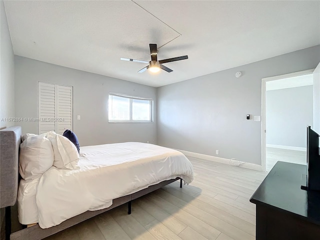 bedroom featuring ceiling fan, a closet, and light hardwood / wood-style floors