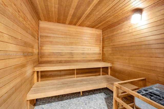 view of sauna featuring wooden ceiling, wood walls, and tile floors