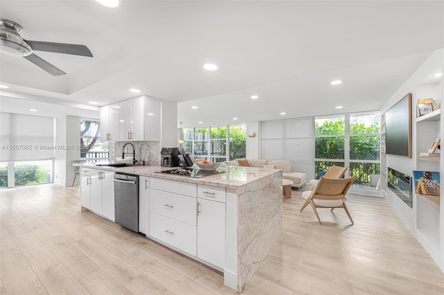 kitchen featuring decorative backsplash, light stone countertops, sink, dishwasher, and white cabinets