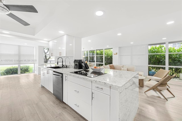 kitchen with light stone countertops, sink, stainless steel dishwasher, black electric cooktop, and white cabinets