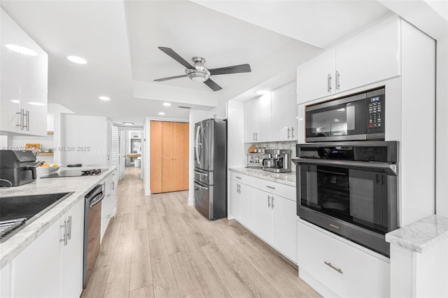 kitchen with sink, white cabinets, stainless steel appliances, and light hardwood / wood-style floors