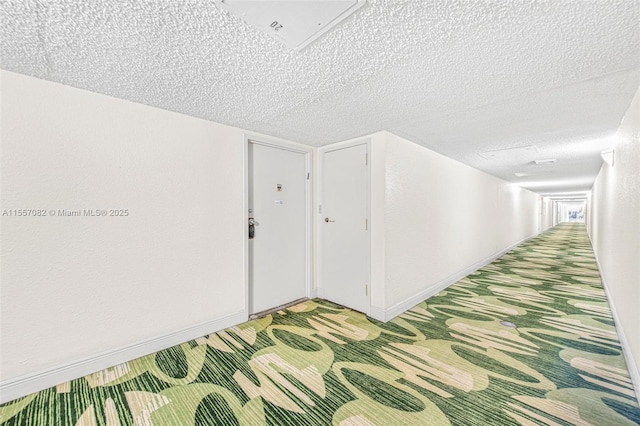 hallway featuring carpet and a textured ceiling