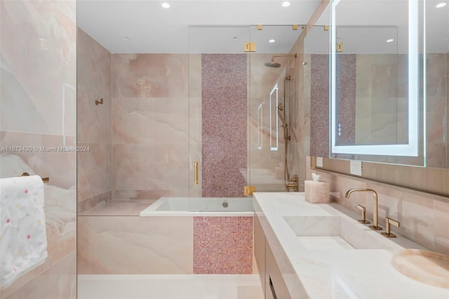 bathroom with tile walls, tasteful backsplash, vanity, and walk in shower