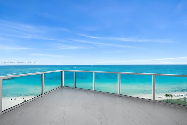 balcony with a water view and a beach view