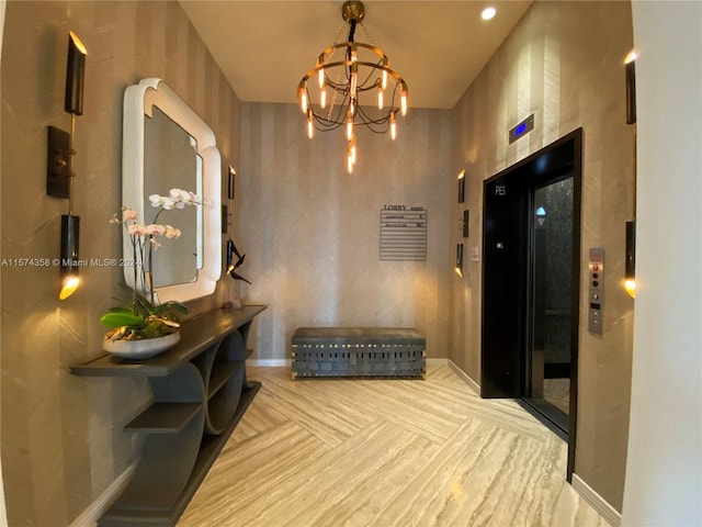 hallway with elevator, a notable chandelier, and light parquet flooring