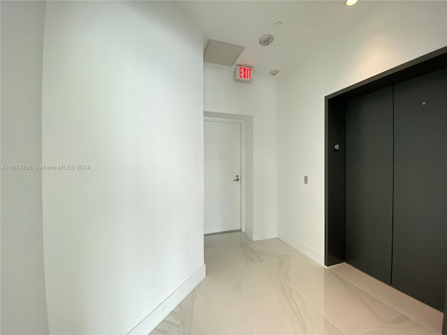 hallway featuring elevator and tile floors