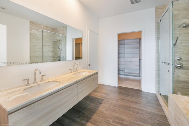 bathroom with an enclosed shower and dual bowl vanity