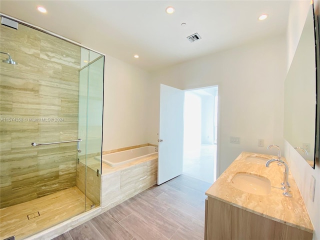 bathroom featuring dual bowl vanity, shower with separate bathtub, and tile flooring