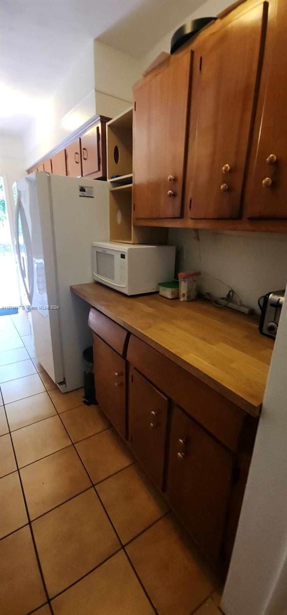 kitchen featuring light tile flooring and built in desk