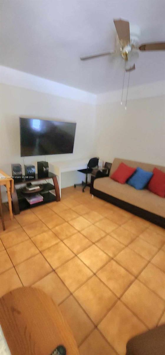 living room with tile floors and ceiling fan