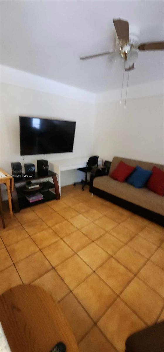 tiled living room featuring ceiling fan