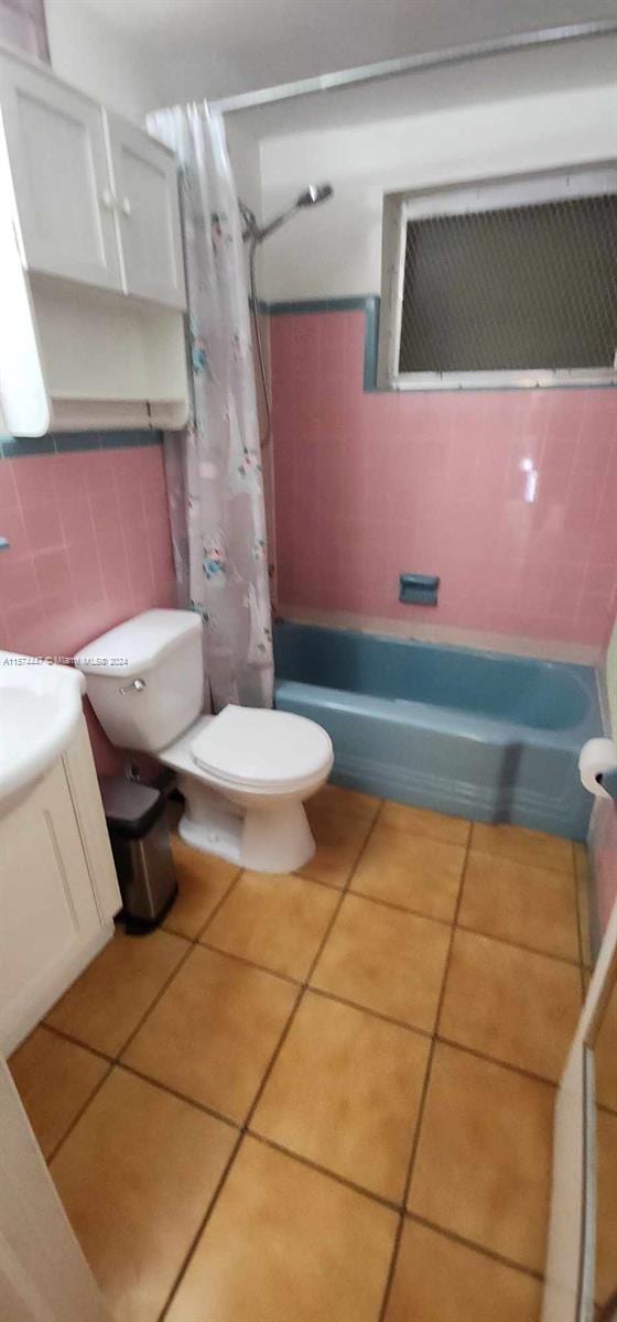 full bathroom with tile walls, shower / tub combo with curtain, tile flooring, tasteful backsplash, and toilet